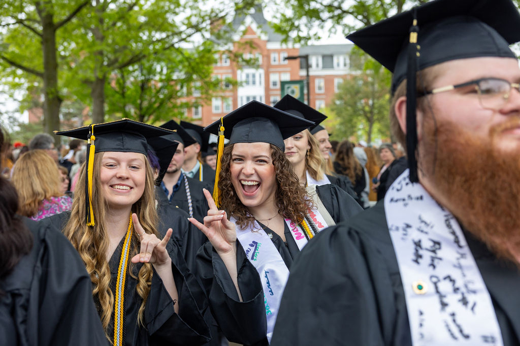 Two students celebrate at graduation. 