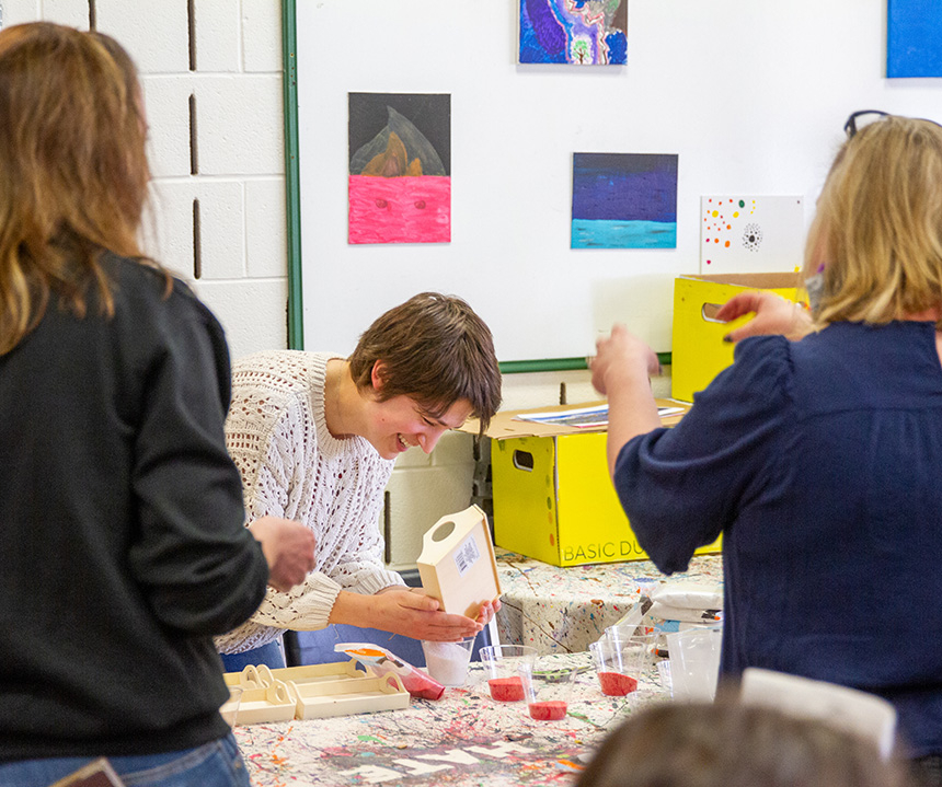 Student pouring liquid into a cup at the wellness passport event