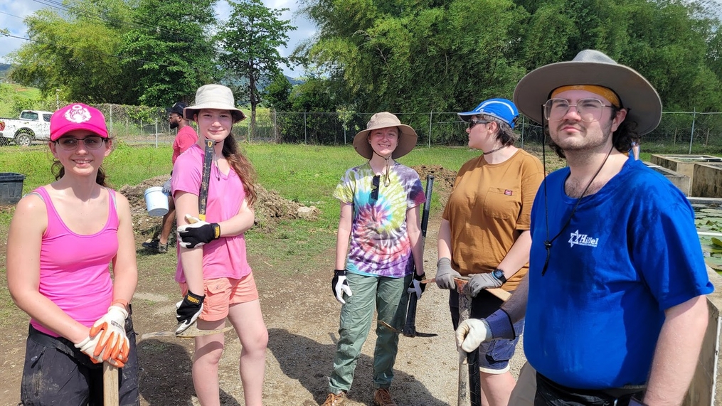 KC students posing with their tools used to dig out lily pad tanks