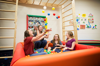 Occupational Therapy Students working with children in ball pit 